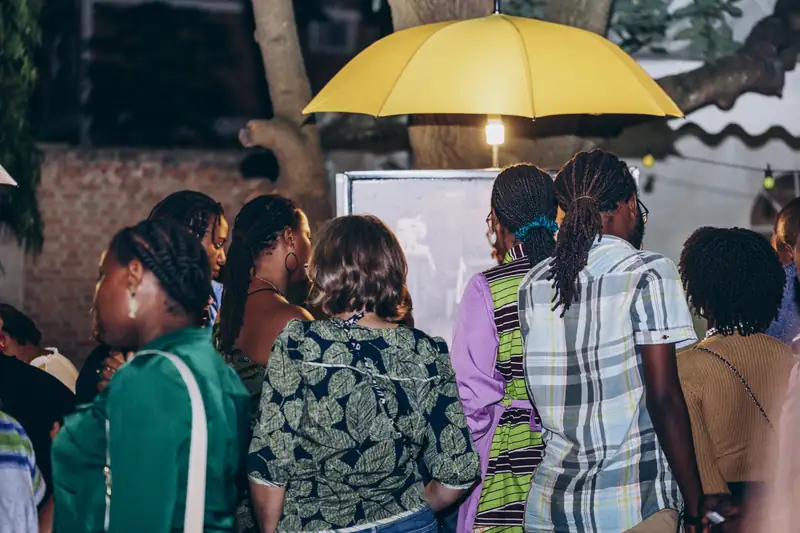 Le public regarde les photographies de l'exposition, le soir du vernissage
