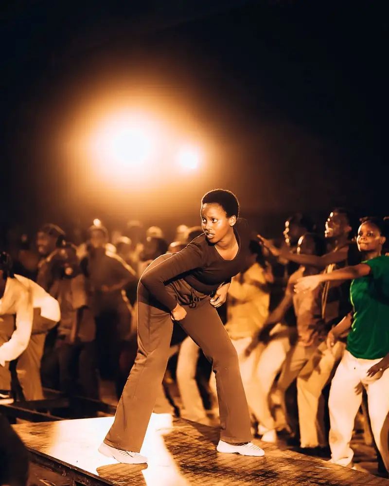 Une troupe de danseurs sur scène, éclairée par les projecteurs