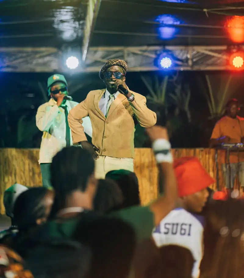 Des chanteurs sur scène face au public, sous les projecteurs colorés